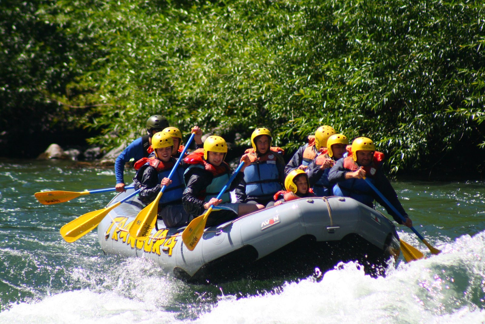 Grupo de personas haciendo canotaje de aventura en los rápidos del Río Chili